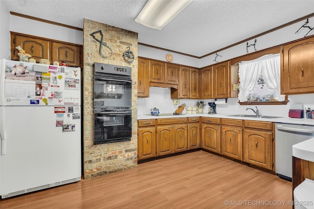 kitchen with crown molding, sink, light hardwood / wood-style floors, a textured ceiling, and black appliances