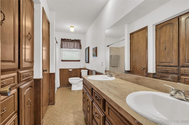 bathroom with a textured ceiling, toilet, and vanity