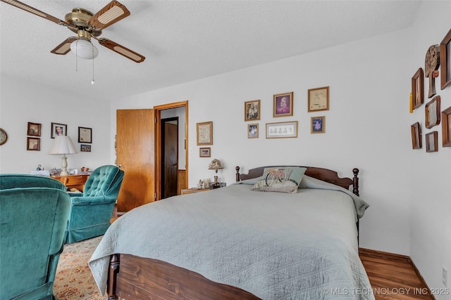 bedroom with ceiling fan, a textured ceiling, and hardwood / wood-style flooring