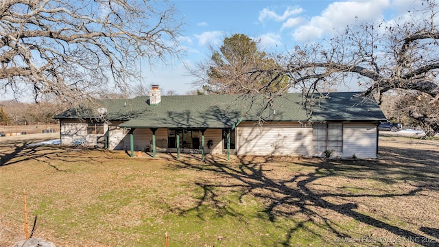rear view of property with a lawn