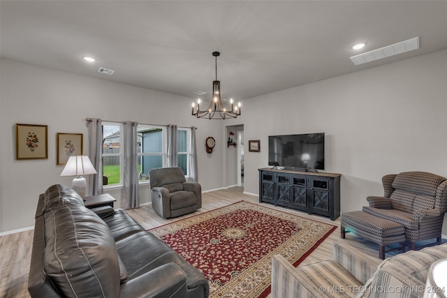 living room featuring light wood-type flooring and an inviting chandelier