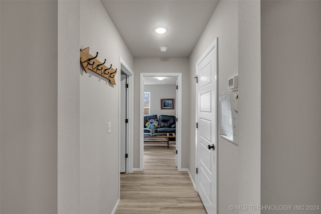 hallway with light hardwood / wood-style floors