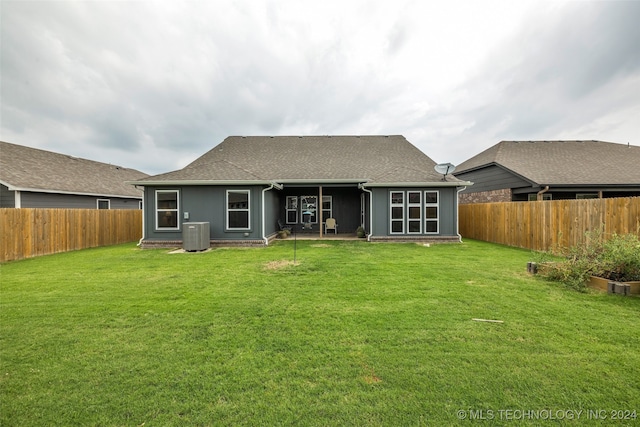 rear view of house featuring central AC, a lawn, and a patio