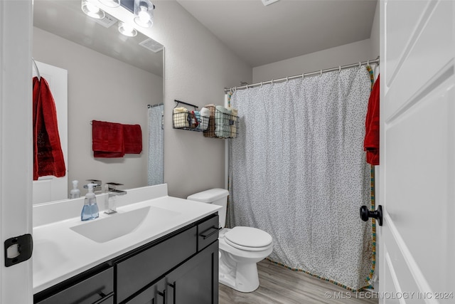 bathroom featuring curtained shower, wood-type flooring, toilet, and vanity