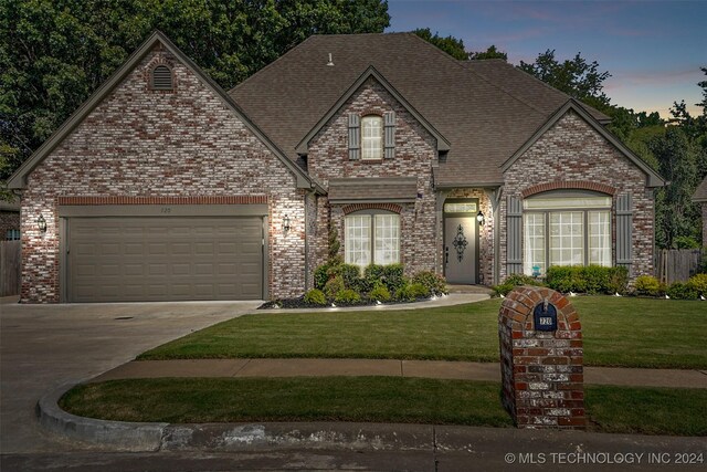 view of front of house featuring a garage and a yard