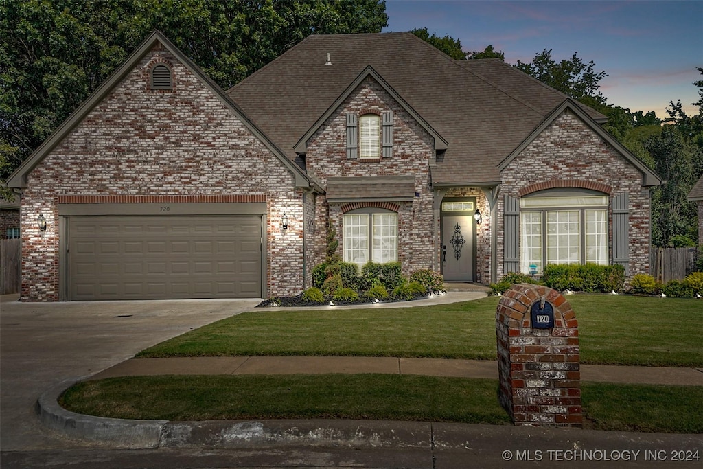 view of front of property featuring brick siding, a shingled roof, concrete driveway, an attached garage, and a front yard