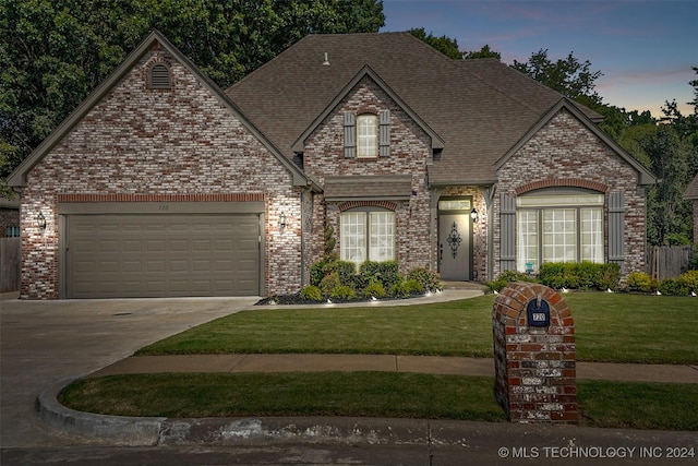 view of front of property featuring brick siding, a shingled roof, concrete driveway, an attached garage, and a front yard