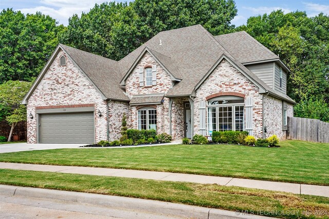 view of front of property featuring a garage and a front lawn