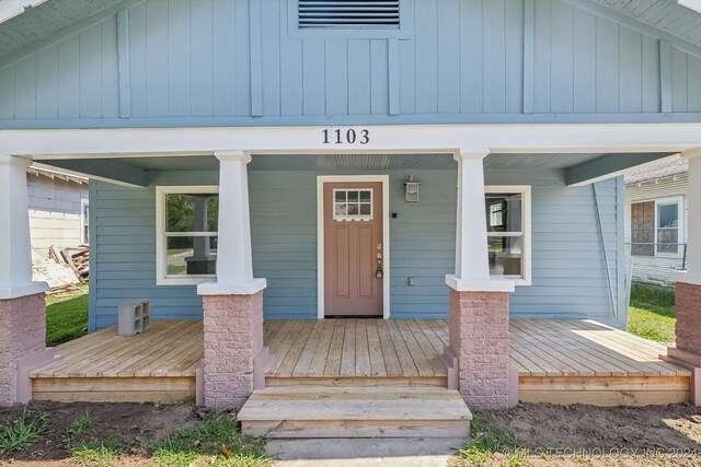 view of exterior entry with a porch