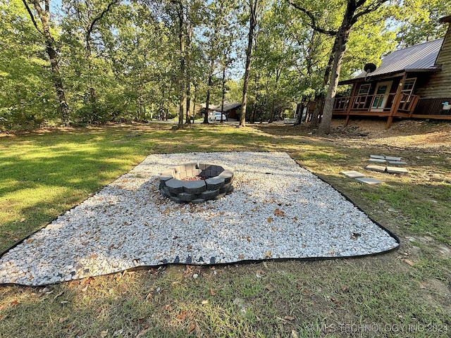 view of yard with a wooden deck and a fire pit