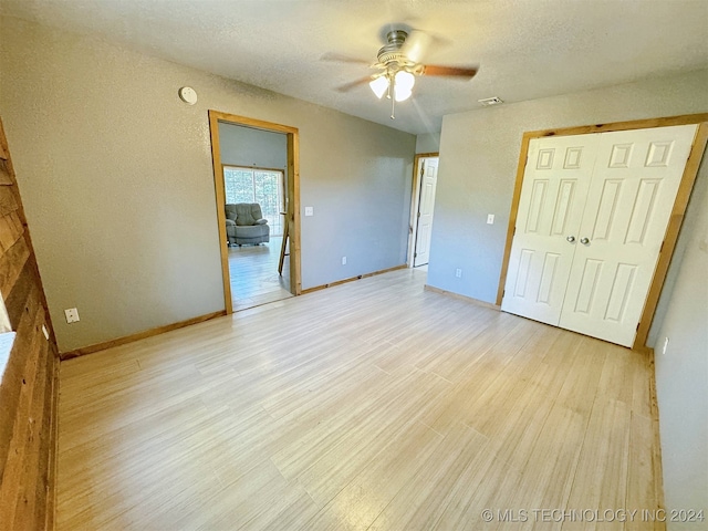 unfurnished bedroom featuring light hardwood / wood-style floors, a textured ceiling, and ceiling fan