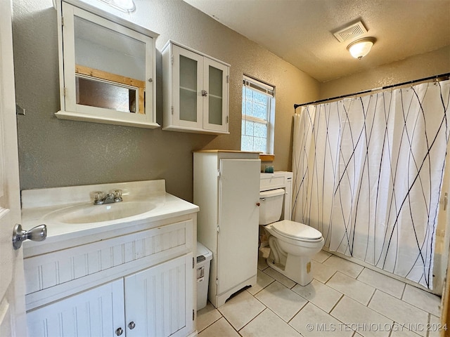 bathroom with a textured ceiling, toilet, tile patterned floors, a shower with curtain, and vanity