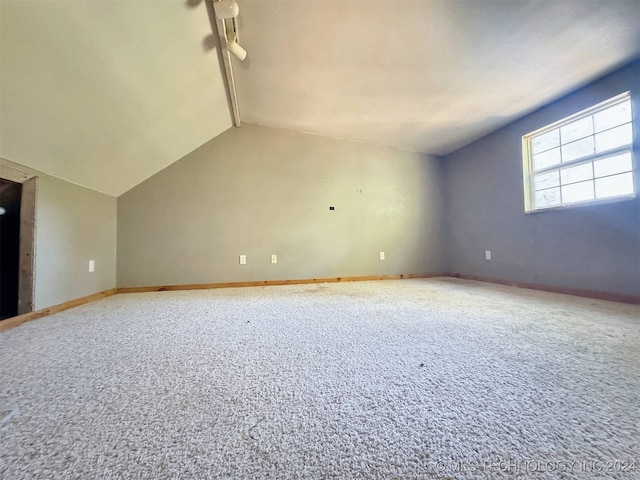 additional living space featuring carpet flooring and vaulted ceiling