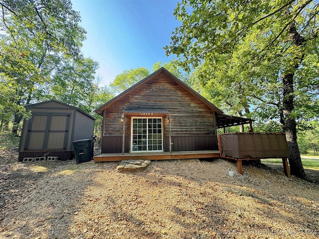 rear view of house featuring a storage shed and a deck