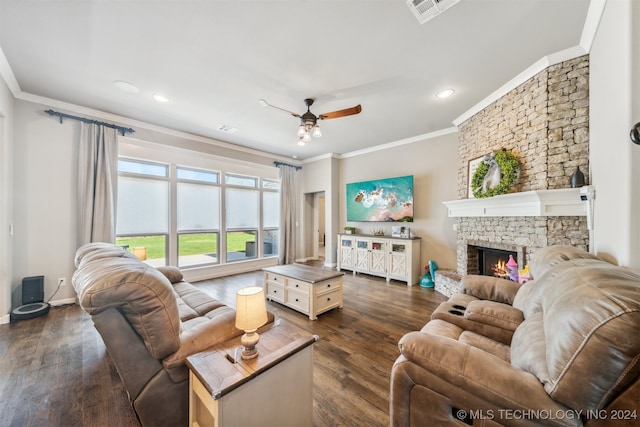 living room featuring ceiling fan, a stone fireplace, crown molding, and dark hardwood / wood-style flooring