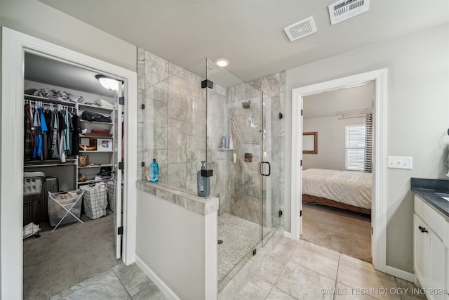 bathroom with an enclosed shower, vanity, and tile patterned flooring