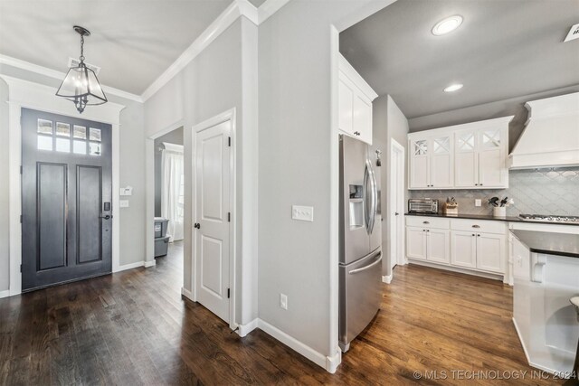 kitchen featuring hanging light fixtures, premium range hood, appliances with stainless steel finishes, and white cabinets