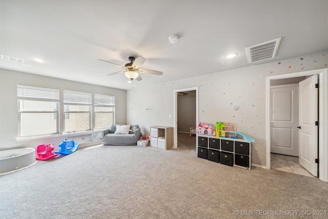 rec room with ceiling fan and light colored carpet