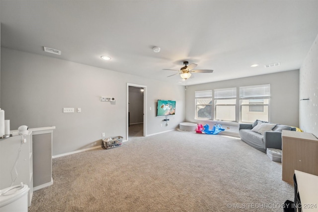 carpeted living room with ceiling fan