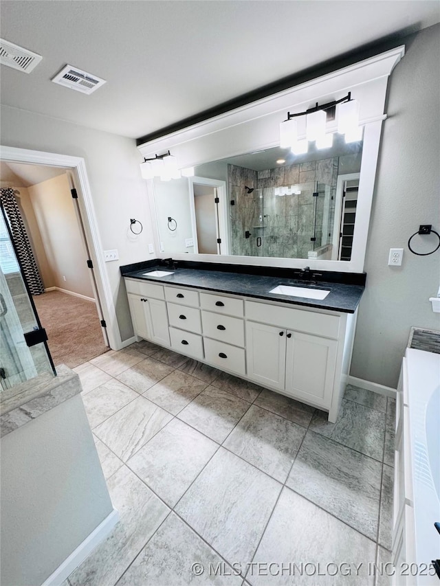 bathroom featuring a shower with door and vanity