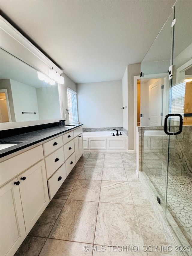 bathroom featuring vanity and independent shower and bath