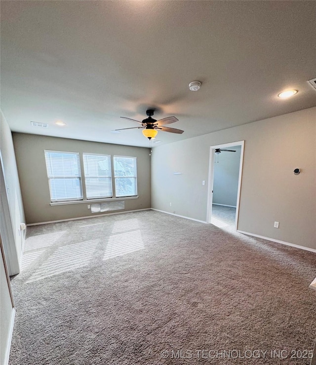 carpeted spare room featuring ceiling fan and a textured ceiling