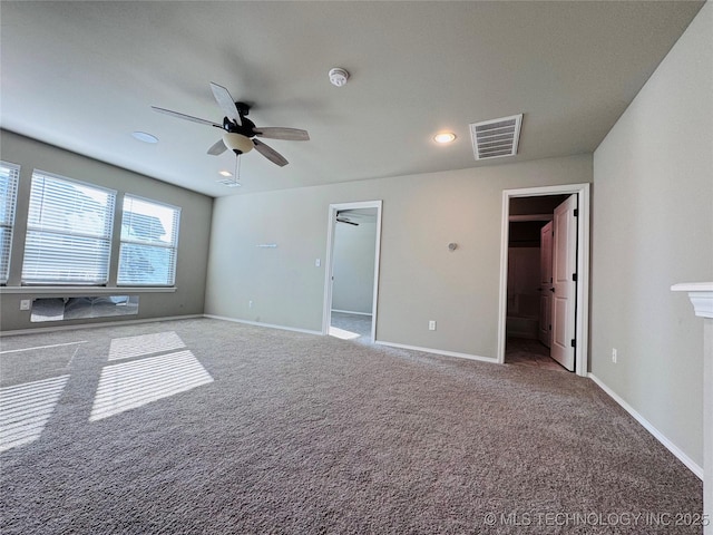 unfurnished bedroom with carpet floors, a walk in closet, and ceiling fan