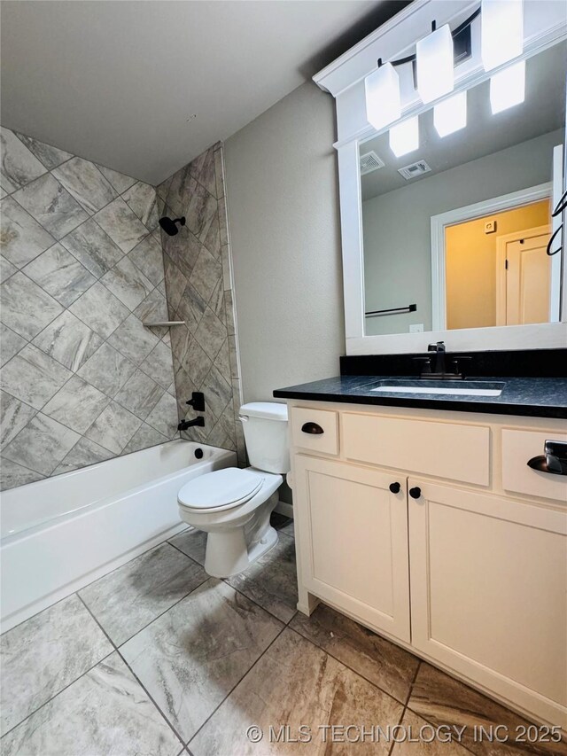 full bathroom with vanity, tiled shower / bath combo, and toilet