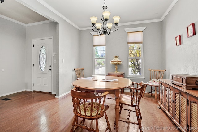 dining room featuring ornamental molding, wood-type flooring, and an inviting chandelier