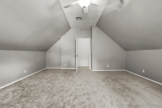 additional living space with vaulted ceiling, carpet flooring, and ceiling fan