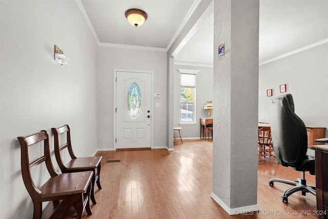 foyer entrance with crown molding and light hardwood / wood-style flooring