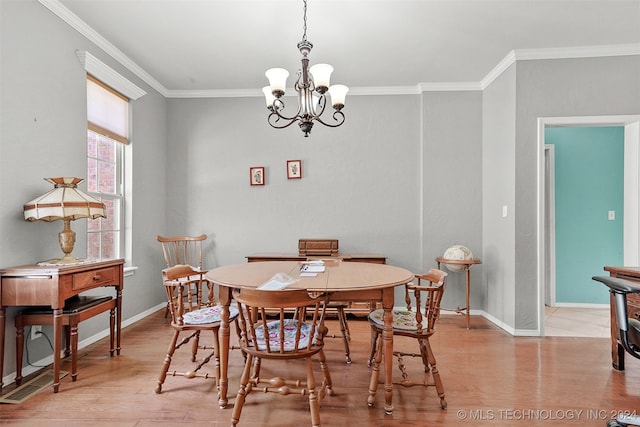 dining space featuring an inviting chandelier, ornamental molding, and light hardwood / wood-style floors