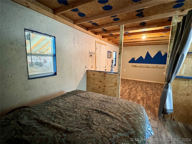 bedroom featuring beamed ceiling and wood-type flooring