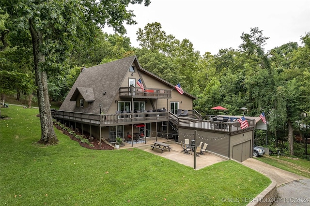 back of property featuring a yard, a garage, a patio area, and a wooden deck