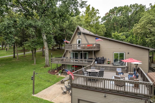 rear view of property with a patio area, a yard, an outdoor hangout area, and a deck