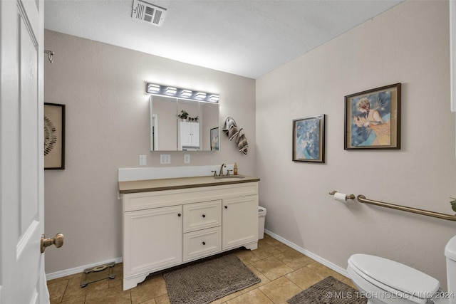 bathroom featuring tile patterned flooring, vanity, and toilet