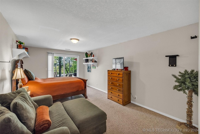 bedroom with carpet floors and a textured ceiling