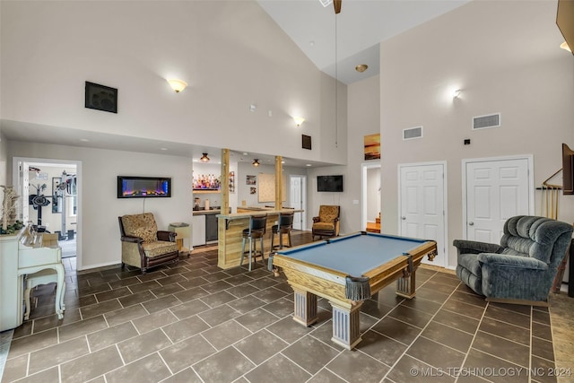 game room featuring bar area, dark tile patterned floors, high vaulted ceiling, and pool table