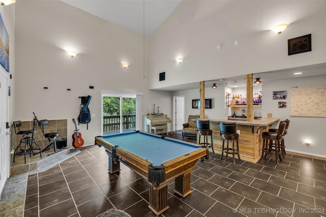 recreation room featuring indoor bar, high vaulted ceiling, dark tile patterned floors, and billiards