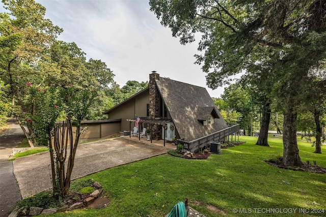 view of side of home with a lawn and central AC