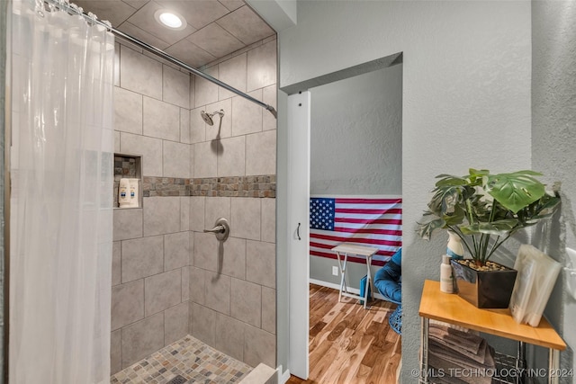 bathroom with a shower with shower curtain and wood-type flooring