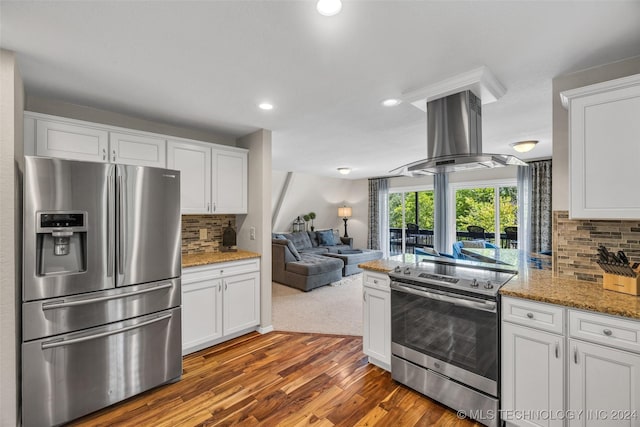 kitchen with decorative backsplash, dark hardwood / wood-style flooring, stainless steel appliances, island range hood, and white cabinetry