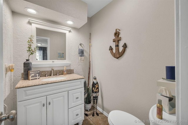 bathroom with tile patterned flooring, vanity, and toilet