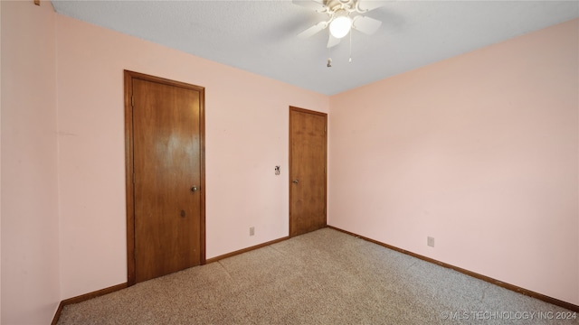 unfurnished bedroom with ceiling fan, a textured ceiling, and light carpet