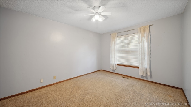 empty room with ceiling fan, carpet floors, and a textured ceiling