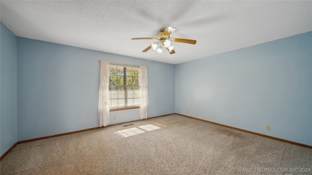 carpeted spare room featuring ceiling fan and a textured ceiling