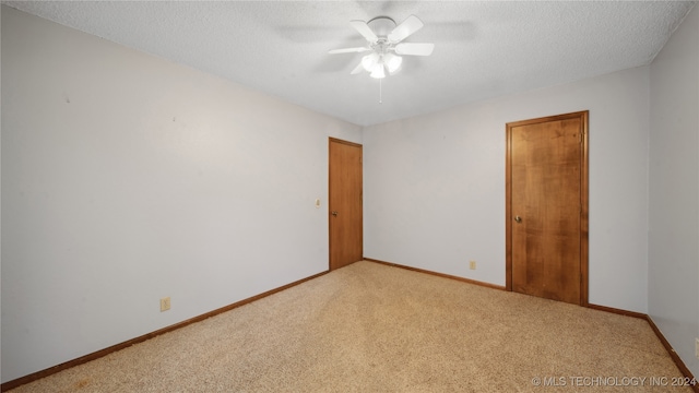 carpeted spare room with ceiling fan and a textured ceiling