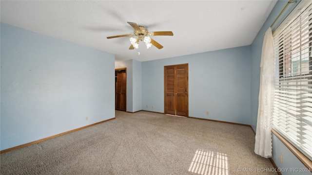 unfurnished bedroom with light carpet, ceiling fan, and a closet