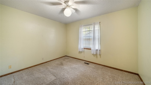 spare room with light carpet, ceiling fan, and a textured ceiling