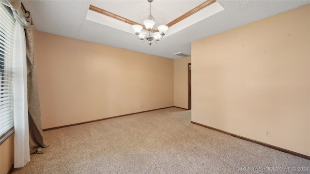 carpeted empty room featuring a chandelier